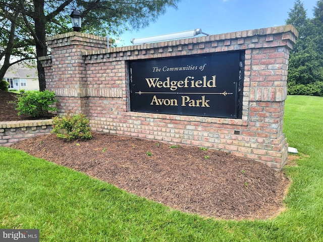community / neighborhood sign featuring a lawn