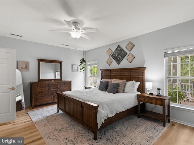 bedroom with light wood finished floors, a ceiling fan, and baseboards