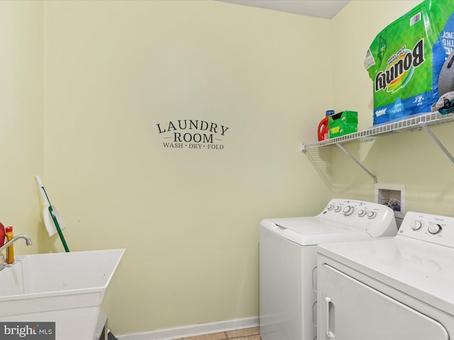 clothes washing area with washer and clothes dryer and baseboards