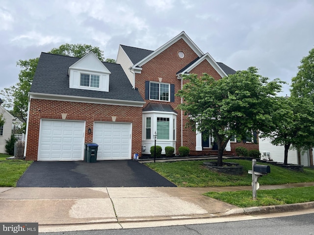 traditional home with driveway, brick siding, an attached garage, a front lawn, and a shingled roof