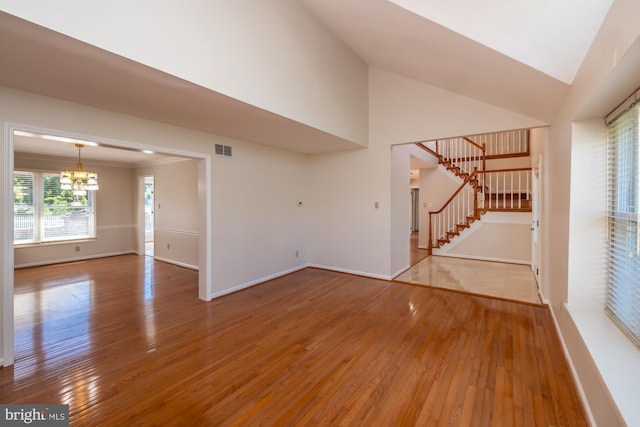 106 Girard Ave, Hatboro, PA 19040 - unfurnished living room with a chandelier, wood-type flooring, stairway, baseboards, and high vaulted ceiling