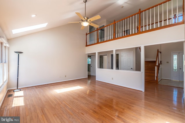 106 Girard Ave, Hatboro, PA 19040 - unfurnished living room featuring high vaulted ceiling, light wood-type flooring, a ceiling fan, a skylight, and baseboards