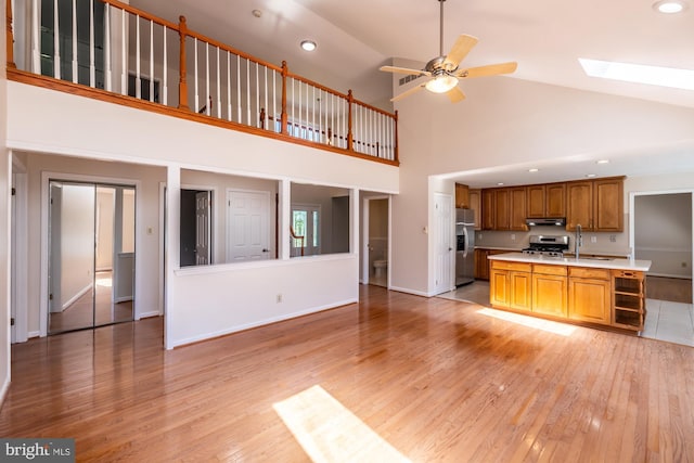 106 Girard Ave, Hatboro, PA 19040 - unfurnished living room with light wood-style floors, a ceiling fan, a skylight, high vaulted ceiling, and recessed lighting