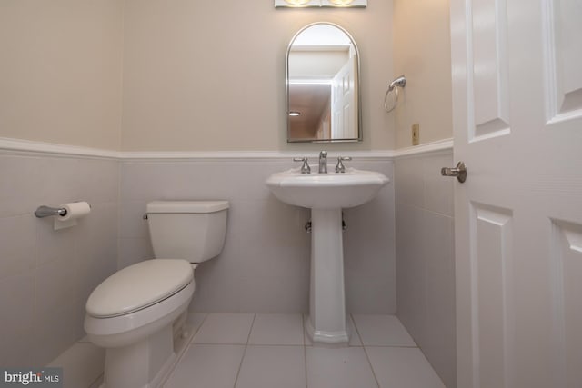106 Girard Ave, Hatboro, PA 19040 - bathroom with tile walls, toilet, a wainscoted wall, and tile patterned floors