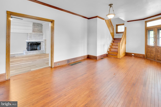 700 Strahle St, Philadelphia, PA 19111 - unfurnished living room featuring hardwood / wood-style flooring, ornamental molding, baseboards, stairs, and a brick fireplace