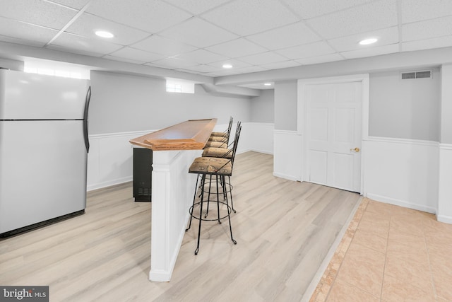 700 Strahle St, Philadelphia, PA 19111 - kitchen featuring freestanding refrigerator, wainscoting, a breakfast bar, light wood finished floors, and a drop ceiling