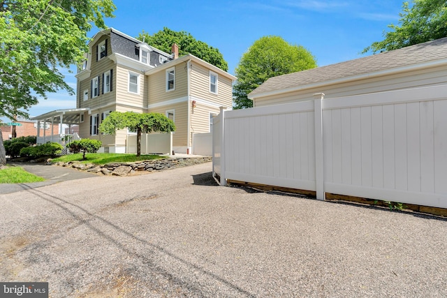 700 Strahle St, Philadelphia, PA 19111 - view of home's exterior with a shingled roof, fence, and mansard roof