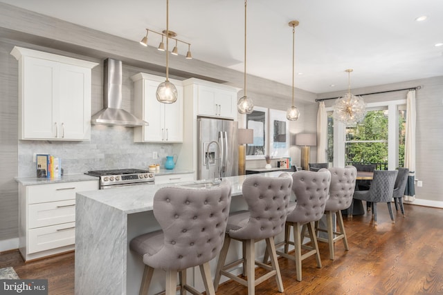 3811 New Hampshire Ave NW Unit 1, Washington, DC 20011 - kitchen with wall chimney exhaust hood, stainless steel appliances, an island with sink, backsplash, and white cabinets