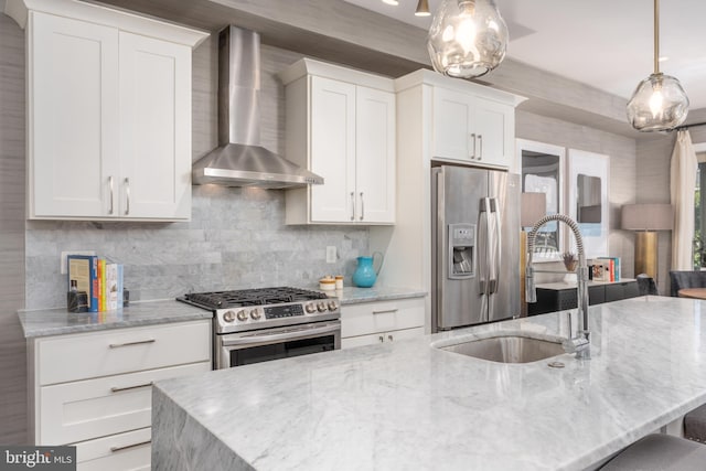 3811 New Hampshire Ave NW Unit 1, Washington, DC 20011 - kitchen featuring wall chimney range hood, appliances with stainless steel finishes, decorative backsplash, white cabinetry, and a center island with sink