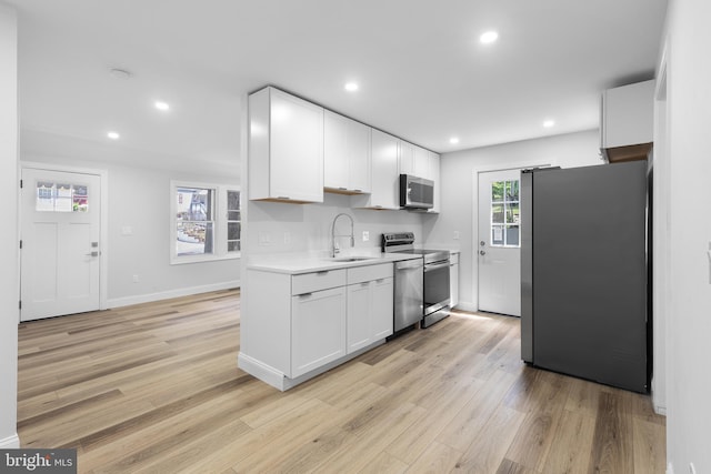 6005 Reed St, Landover, MD 20785 - kitchen featuring stainless steel appliances, a sink, light countertops, light wood-style floors, and white cabinets