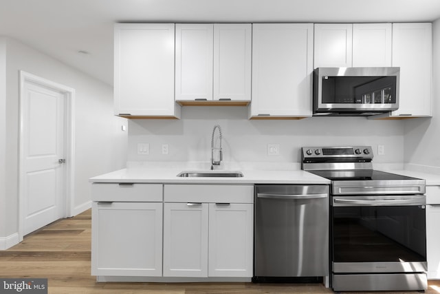 6005 Reed St, Landover, MD 20785 - kitchen with stainless steel appliances, a sink, white cabinetry, and light countertops