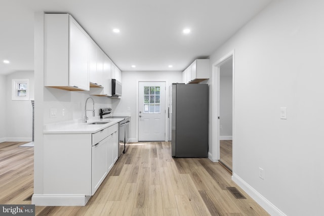 6005 Reed St, Landover, MD 20785 - kitchen featuring freestanding refrigerator, stove, a sink, light countertops, and light wood-style floors