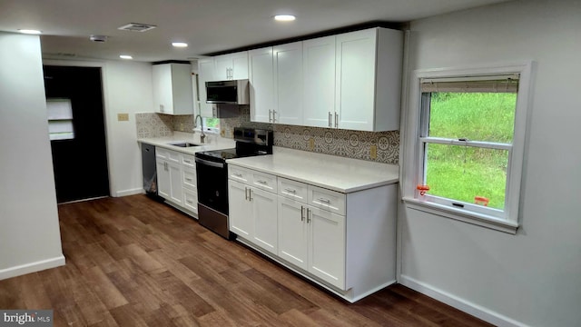 kitchen featuring range with electric stovetop, a sink, dishwashing machine, baseboards, and recessed lighting