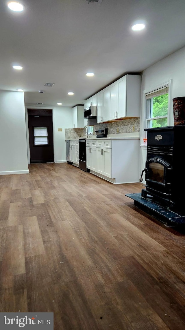 kitchen with wood finished floors, white cabinets, tasteful backsplash, light countertops, and recessed lighting