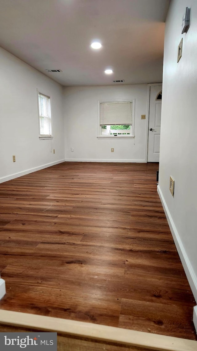 empty room featuring recessed lighting, wood finished floors, and baseboards