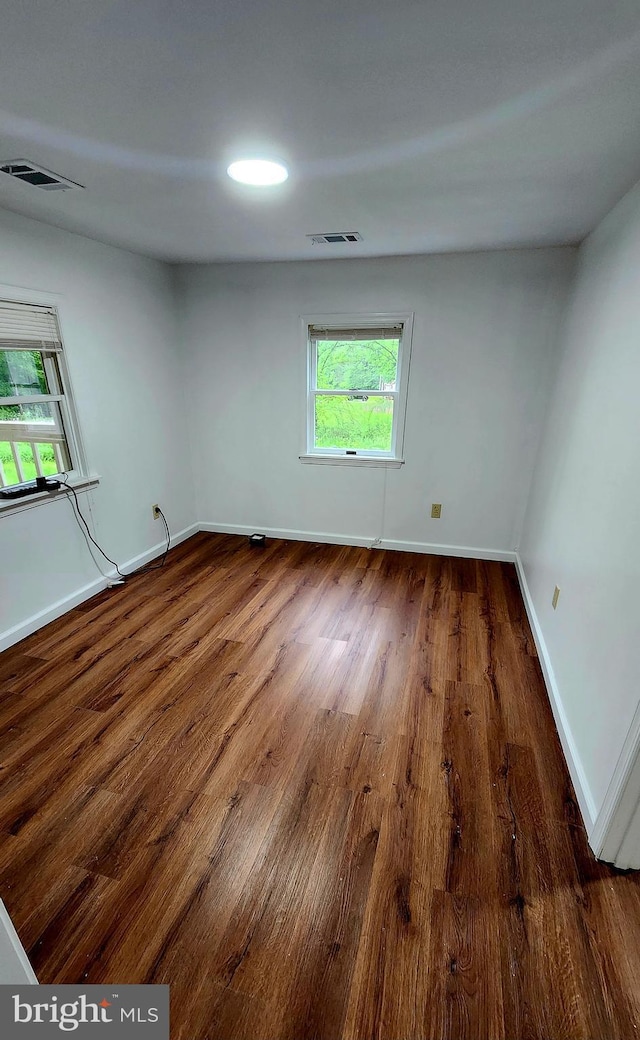 empty room featuring wood finished floors and baseboards