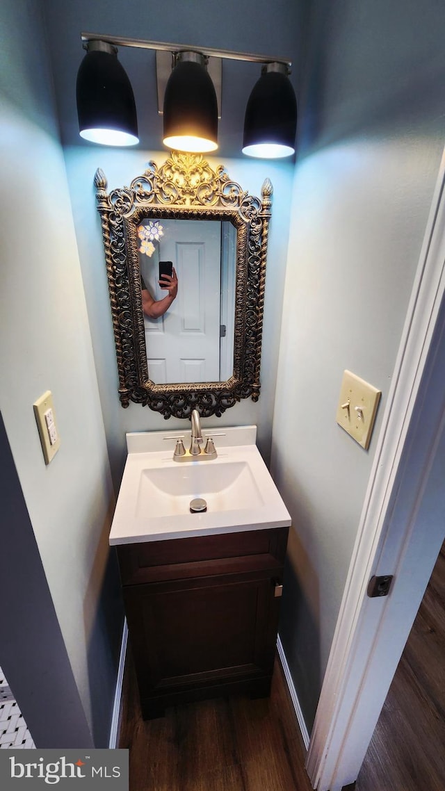 bathroom featuring vanity, wood finished floors, and baseboards