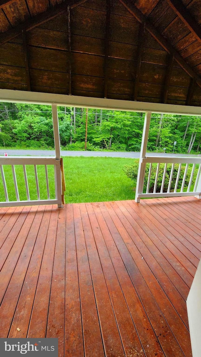 wooden deck featuring a lawn