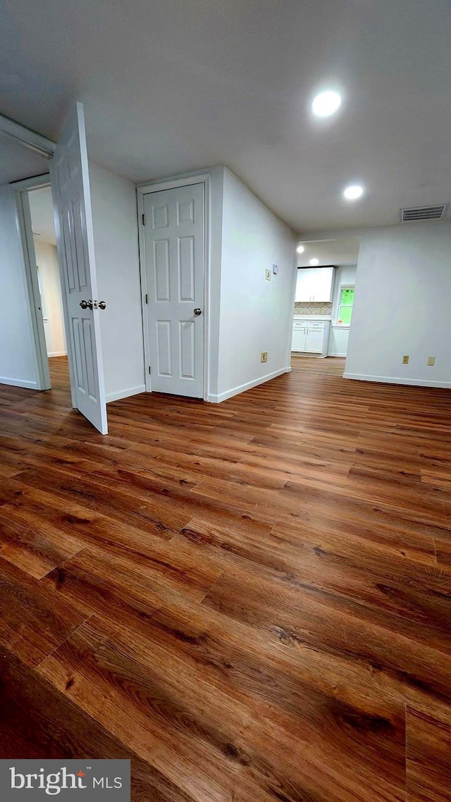 empty room featuring wood finished floors, baseboards, and recessed lighting