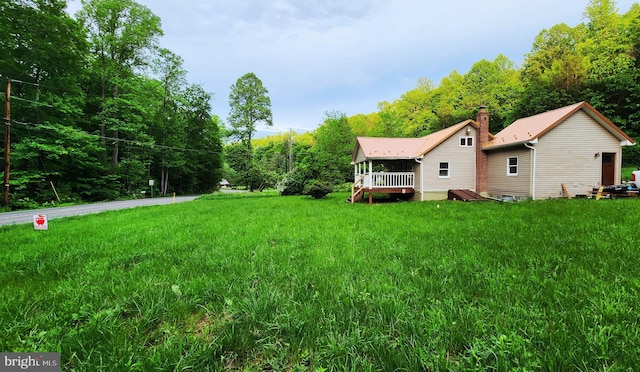 view of green lawn featuring a deck