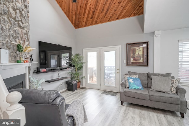 living room featuring wood ceiling, wood finished floors, a fireplace, and high vaulted ceiling