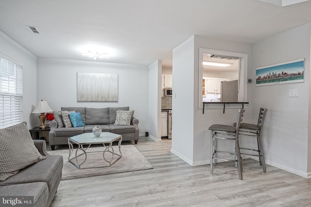 living room featuring light wood-type flooring and baseboards