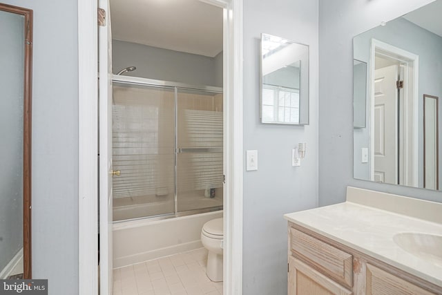 bathroom featuring toilet, tile patterned floors, vanity, and enclosed tub / shower combo