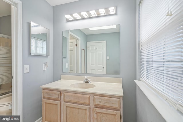 bathroom with vanity, toilet, and baseboards