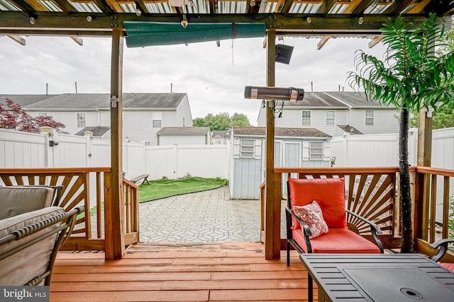 deck with a storage shed, a fenced backyard, and an outbuilding