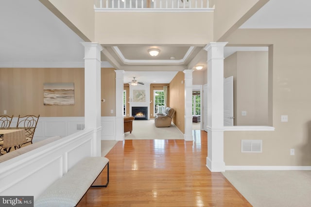 217 Liberty Trail Ct W, Fountainville, PA 18923 - foyer entrance with ornate columns, a lit fireplace, wood finished floors, crown molding, and baseboards