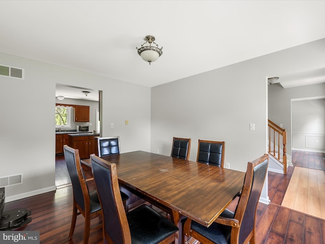 325 Chandler Dr, Shepherdstown, WV 25443 - dining area featuring dark wood finished floors, stairway, and baseboards