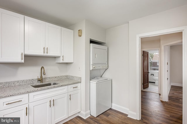 3010 Woodring Ave, Baltimore, MD 21234 - laundry room with a sink, stacked washer and clothes dryer, dark wood-type flooring, and baseboards
