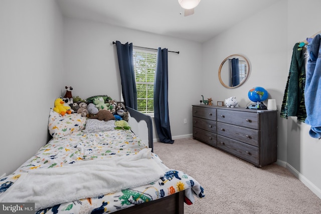 carpeted bedroom featuring baseboards and a ceiling fan
