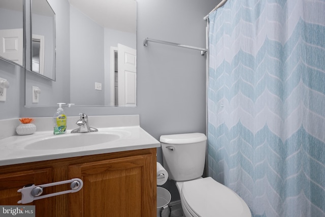 bathroom featuring vanity, toilet, and curtained shower