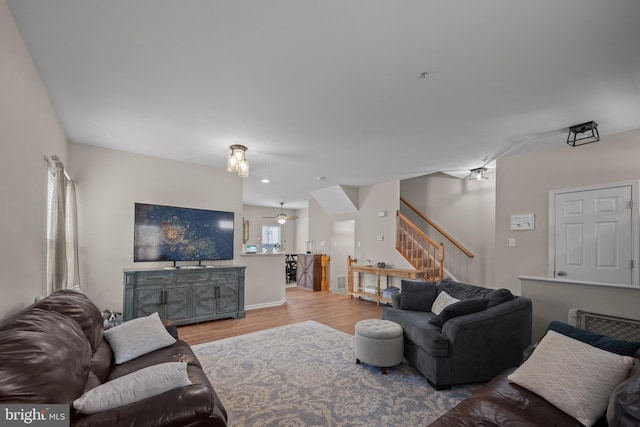 living area featuring stairway, wood finished floors, and ceiling fan