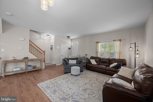 living area with stairs, wood finished floors, and baseboards