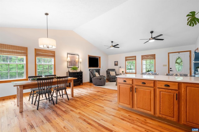 kitchen with light wood finished floors, light countertops, vaulted ceiling, and open floor plan