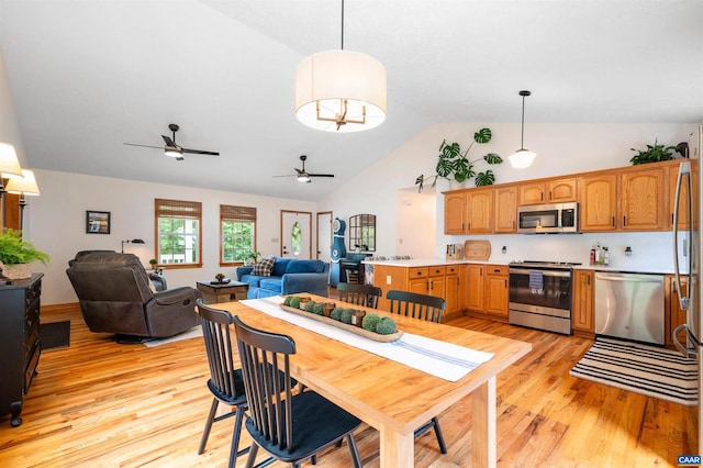 dining room with light wood-style floors, a ceiling fan, and high vaulted ceiling