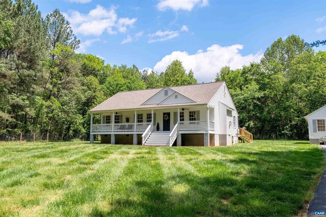 view of front of property with stairway, a front lawn, ceiling fan, and roof with shingles