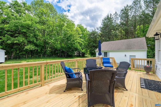 wooden terrace with outdoor dining space and view of wooded area