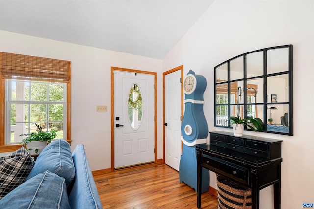 foyer featuring plenty of natural light, light wood finished floors, and vaulted ceiling
