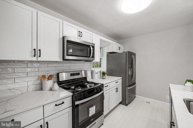 8226 Dorset Ave, Rosedale, MD 21237 - kitchen featuring appliances with stainless steel finishes, tasteful backsplash, and white cabinets