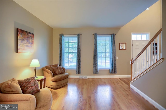 living area featuring healthy amount of natural light, wood finished floors, and baseboards