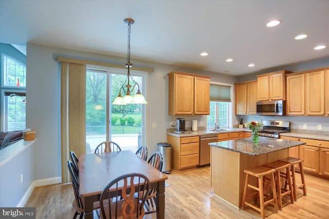 kitchen featuring stainless steel appliances, healthy amount of natural light, recessed lighting, and light wood-style flooring