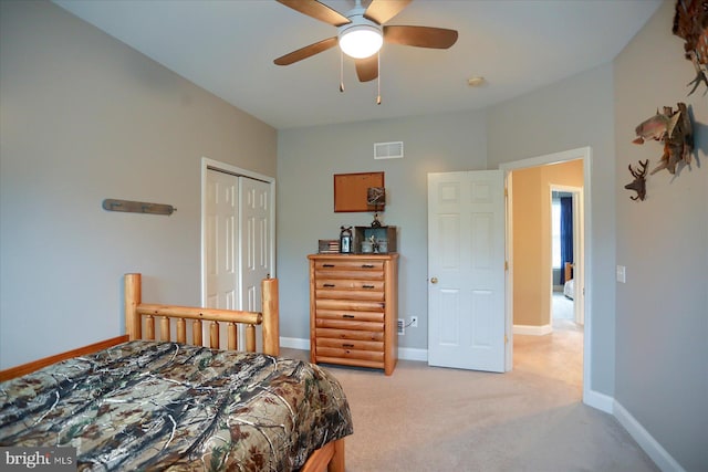 bedroom featuring light carpet, a closet, baseboards, and ceiling fan