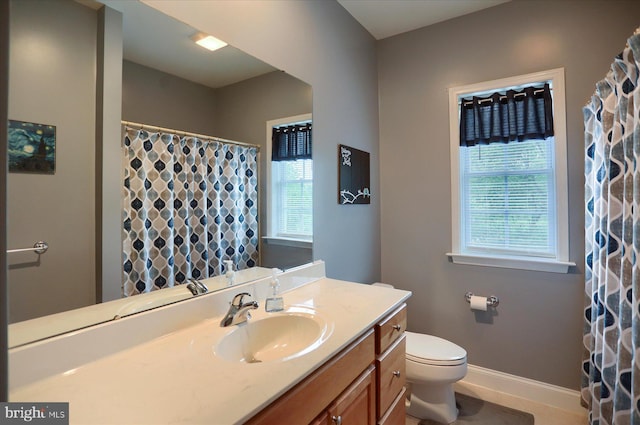 bathroom featuring baseboards, toilet, and vanity