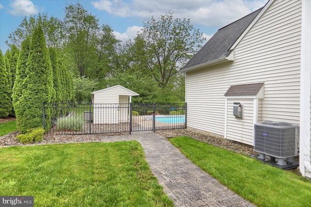 view of yard featuring central air condition unit, an outbuilding, and a patio