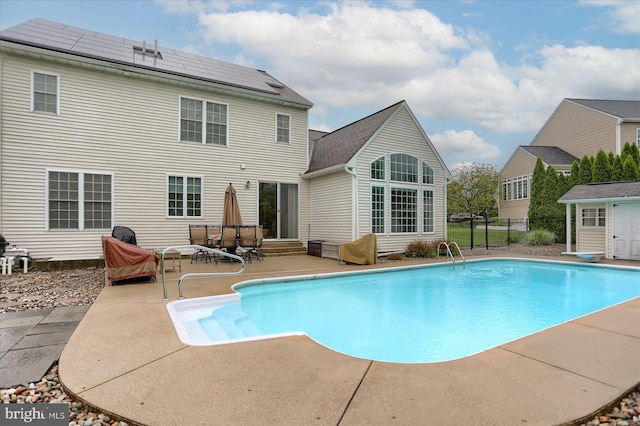 outdoor pool with a patio and fence