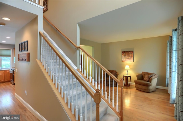 stairs featuring wood finished floors, baseboards, and recessed lighting
