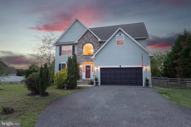 traditional home with driveway, stone siding, and a garage